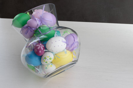 Glass vase filled with colorful Easter eggsの写真素材