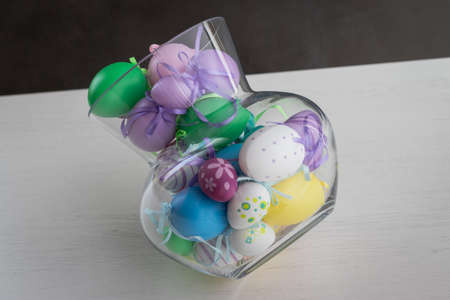 Glass vase filled with colorful Easter eggsの写真素材