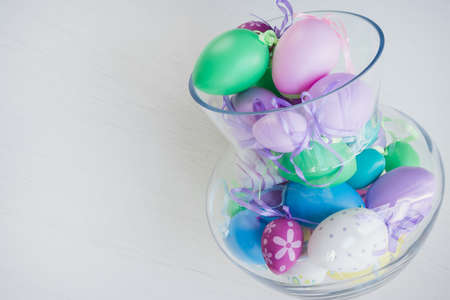 Glass vase filled with colorful Easter eggsの写真素材