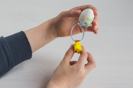 Boy with plastic Easter egg decoration on his handsの写真素材