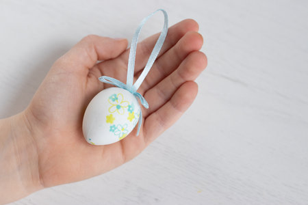 Boy with plastic Easter egg decoration on his handsの写真素材