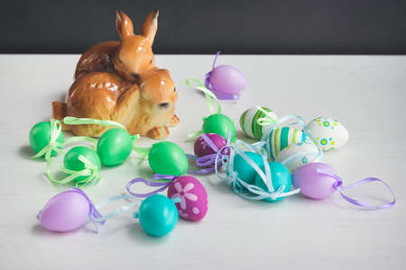 Easter symbols decoration table, ceramic bunnies and plastic Easter eggsの写真素材