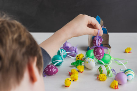 Boy with plastic Easter egg decoration on his handsの写真素材