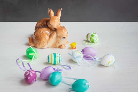 Easter symbols decoration table, ceramic bunnies and plastic Easter eggsの写真素材