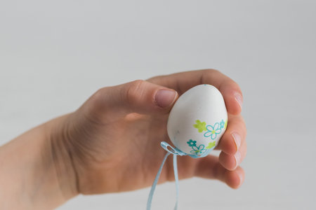 Boy with plastic Easter egg decoration on his handsの写真素材