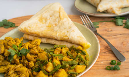 Indian-surinamese spicy food lunch and dinner roti chicken curry mealの写真素材