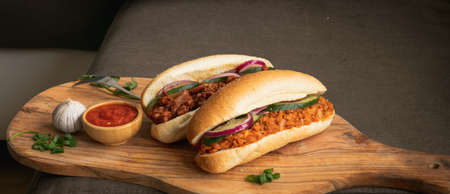 Baked cod fish sandwich with salad and red sauceの写真素材