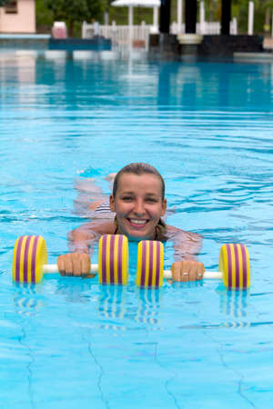 Aqua aerobic. Woman is engaged aqua aerobics in water