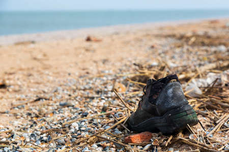 Pollution: shoes on the beach after winter storms.の写真素材
