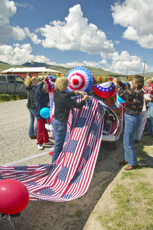 Women decorating a car in red, white & blue in Lima Montanaのeditorial素材
