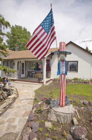 Country home with an Uncle Sam wood carving and American flagのeditorial素材