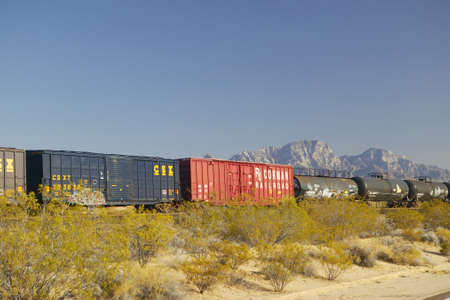Freight train travels through desert and mountainous areas of Mojave Desert in Southern Californiaのeditorial素材