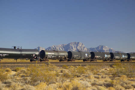 Freight train travels through desert and mountainous areas of Mojave Desert in Southern Californiaのeditorial素材