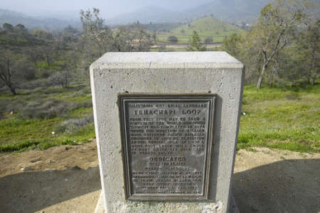 A monument sign from 1955 showing the Tehachapi Train Loop near Tehachapi California is the historic location of the Southern Pacific Railroad where freight trains gain 77 feet in elevation and show freight cars traveling in giant loopのeditorial素材