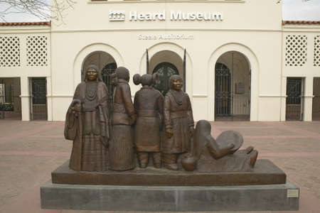 The front entrance of the Heard Museum showing a sculpture of Native Americans in Phoenix, Arizonaのeditorial素材