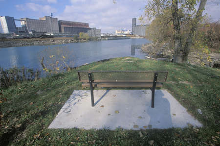 A bench overlooking an industrial park on the Rouge River in Detroit, Michiganのeditorial素材