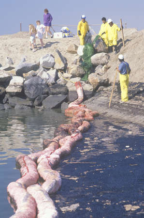 A team of environmentalists clean up an oil spill in Huntington beach, Californiaのeditorial素材