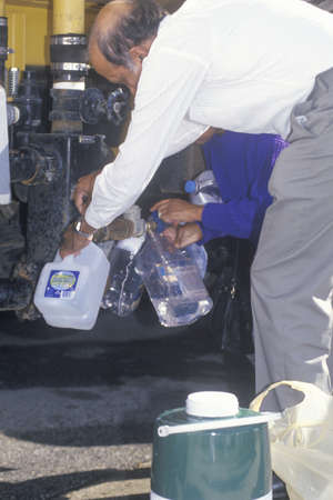 An older couple securing some water from a water line after the Northridge earthquake in 1995のeditorial素材