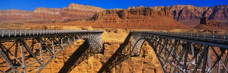 This is a Navajo Bridge that crosses the Colorado River. In the background are the Vermillion Cliffs of Red Rock. This is a double bridge made of steel.の写真素材