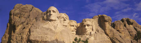 This is a close up view of Mount Rushmore National Monument against a blue sky. It shows the four faces of George Washington, Thomas Jefferson, Theodore Roosevelt, and Abraham Lincoln.のeditorial素材