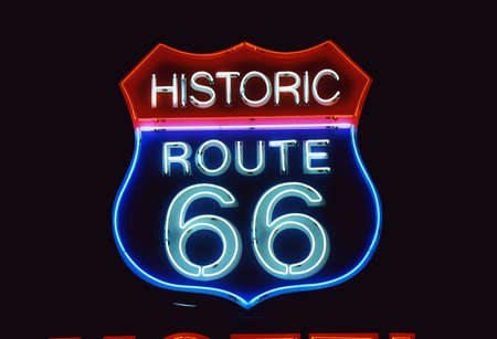 This is a road sign that says Historic Route 66. It is a neon sign in red, white and blue against a black night sky.のeditorial素材