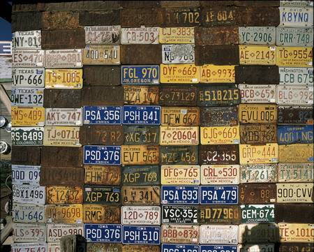 This is a wall of old license plates. It is a piece of roadside Americana. There are license plates from Texas, Iowa, New Jersey, California and other places.のeditorial素材