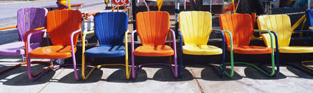 This is a close up of multi-colored metal lawn chairs. They are located outdoors on Route 66.のeditorial素材