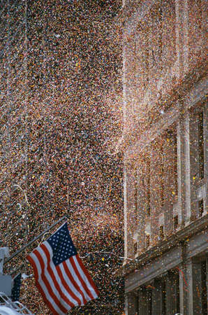 This is a shot of confetti and ticker tape falling like snow at the Ticker Tape Parade for the Desert Storm Victory. An American flag is waving at the bottom left hand corner.の写真素材