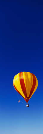 This is the 25th Annual Albuquerque International Balloon Fiesta. It shows a red and yellow balloon that is part of the mass ascension of colorful balloons.のeditorial素材