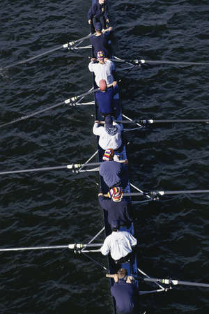 Crew team rowing on waterの写真素材