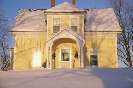 Home covered in icicles and snow at sunrise, Vermontのeditorial素材