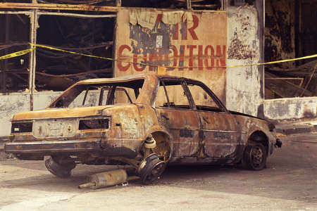 Charred car with blown-out tired and windowsの写真素材