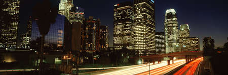 Lit skyscrapers and traffic against night sky
