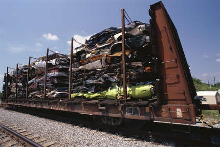 Junked smashed cars on railroad car