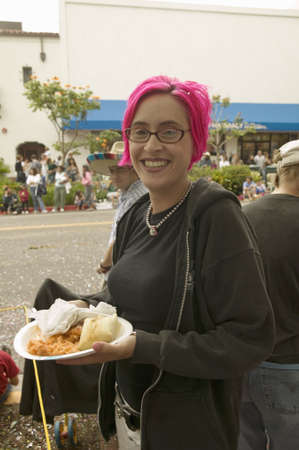 Girl with purple hair eats food at annual Old Spanish Days Fiesta held every August in Santa Barbara, Californiaのeditorial素材