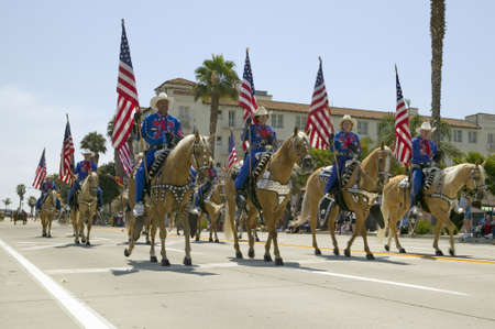 Cowboys marching with American Flags displayed during opening day parade down State Street, Santa Barbara, CA, Old Spanish Days Fiesta, August 3-7, 2005のeditorial素材