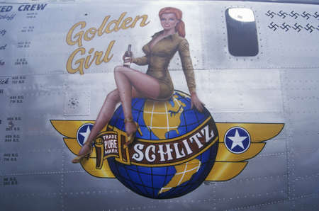 A B24 Liberator bomber is decorated with the Schlitz Golden Girl logo and swastika marks for the number of German planes downed during World War II. The bomber sits on display to commemorate World War II air forces at Burbank Airport in Californiaのeditorial素材