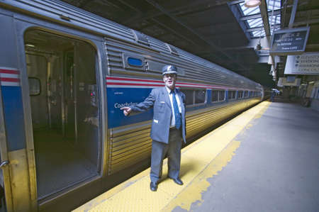 "Conductor at Amtrak train platform announces ""All Aboard"" at East Coast train station on the way to New York City, New York, Manhattan, New York"のeditorial素材