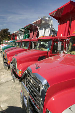 Bright red Mack dump trucks line the road in a row, in Maine near the New Hampshire borderのeditorial素材