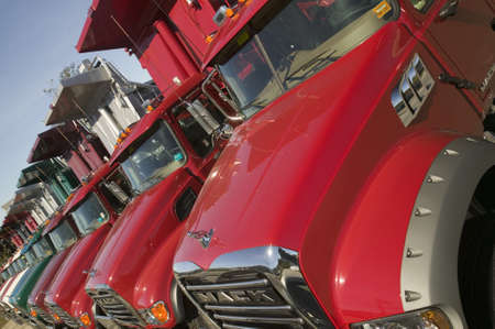 Bright red Mack dump trucks line the road in a row, in Maine near the New Hampshire borderのeditorial素材