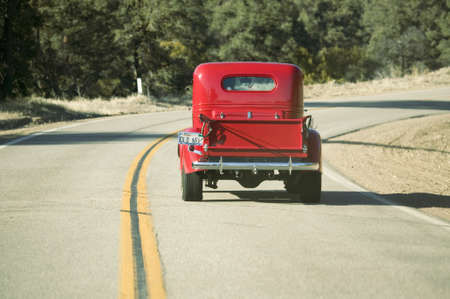 A restored bright Red Roadster hotrod pickup truck, mid-30's, drives rural highway in Kern County near Lockwood Valley, CAのeditorial素材