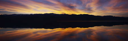 Panoramic view at sunset of flooded salt flats and Panamint Range Mountains in Death Valley National Park, Californiaのeditorial素材