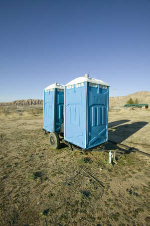 Two out houses, mobile blue bathrooms, sit on trailer in the middle of a field in Ventura County, California off of highway 33 near Cuyamaのeditorial素材