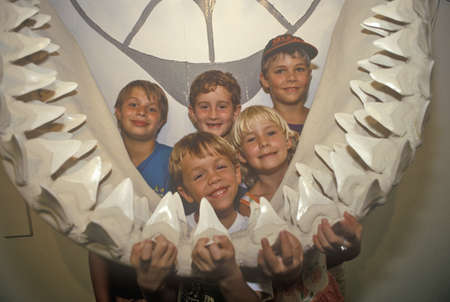 Children pose with giant jaw of marine mammal at the Shell Factory, Fort Myers, Floridaのeditorial素材