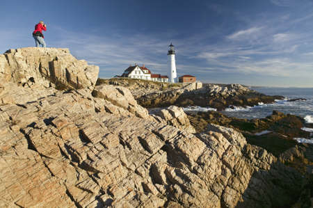 Photographer in red sweatshirt photographs Portland Head Lighthouse, Cape Elizabeth, Maineのeditorial素材