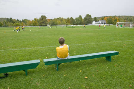 A boy rests on a bench during school soccer practice, New Hampshireのeditorial素材
