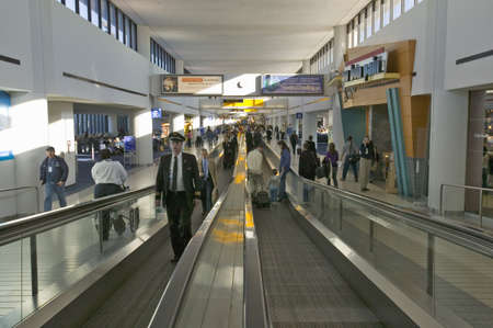 Travelers and airline industry personnel on moving sidewalks in Newark International Airport, New Jerseyのeditorial素材