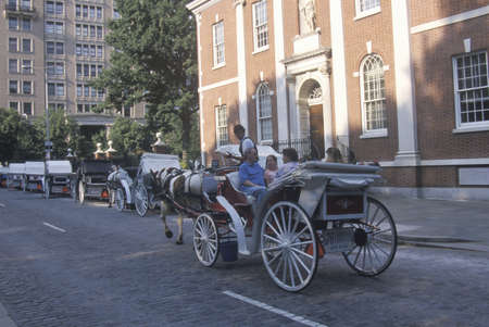 Horse and carriage riding in historic district of old Philadelphia, PA, in front of Independence Hall, home of Declaration of Independence and US Constitutionのeditorial素材