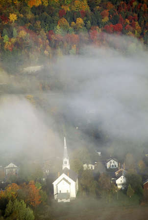 Aerial view of church steeple wreathed in morning fog in autumn, Waitsfield, VTのeditorial素材