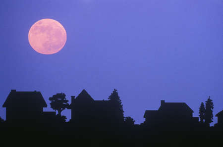 Silhouette of full moon over family homes in typical neighborhoodのeditorial素材